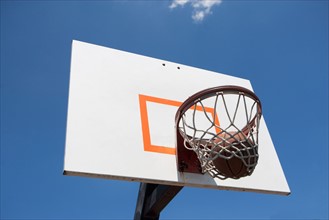 USA, Florida, Miami, Low angle view of basketball hoop with basketball inside. Photo : fotog