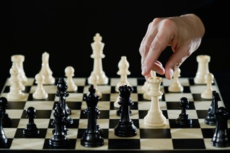 Close-up of man's hand playing chess.