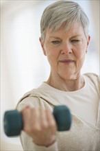 Senior woman lifting weights.