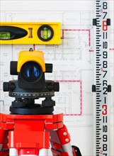 Close-up of theodolite, blueprint in the background.