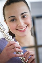 Teenage girl (14-15) posing with flute .