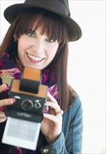 Portrait of young woman with instant camera.