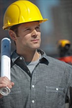 Portrait of worker holding blueprint.