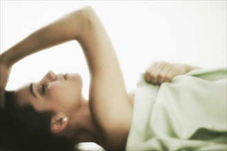 Profile of young woman lying in bed .