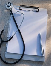 Stethoscope, clipboard and pen, studio shot. Photo : Daniel Grill