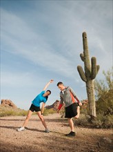 USA, Arizona, Phoenix, Mid adult man and young woman exercising on desert.