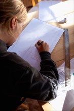 Female architect drawing plans. Photo : Noah Clayton