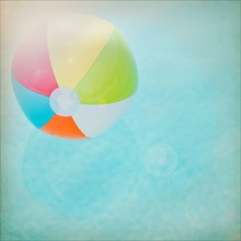 Close up of striped beach ball against water surface. Photo : Jamie Grill Photography