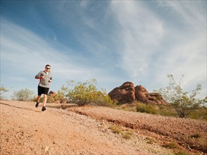 USA, Arizona, Phoenix, Mid adult man jogging on desert.