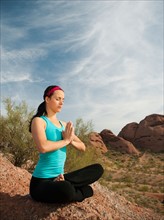 USA, Arizona, Phoenix, Young woman practicing yoga on desert.