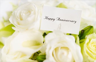 Happy anniversary card on bouquet of roses.