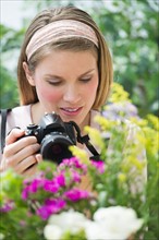 Young woman photographing flowers.