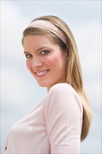 Portrait of young woman smiling outdoors.