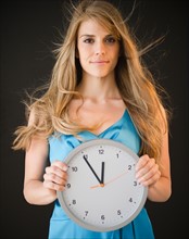 Portrait of woman holding clock. Photo: Jamie Grill