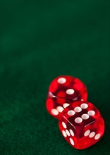 Close up of red dices on green felt. Photo: Daniel Grill