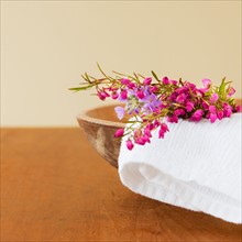 Still life with purple flowers, towel and wooden bowl. Photo : Daniel Grill