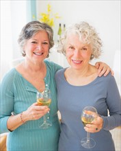 Two senior women holding wine glasses. Photo : Daniel Grill