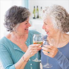 Two senior women holding wine glasses. Photo : Daniel Grill