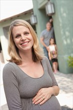 Portrait of pregnant mother with family in background. Photo: Rob Lewine