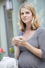 Pregnant woman enjoying cup of tea. Photo : Rob Lewine