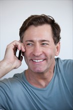 Portrait of mature man with mobile phone. Photo : Rob Lewine