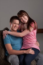 Portrait of teenage boy (16-17) embracing with young woman, studio shot. Photo : Rob Lewine