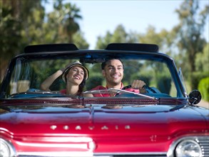 Young couple driving convertible car. Photo : db2stock