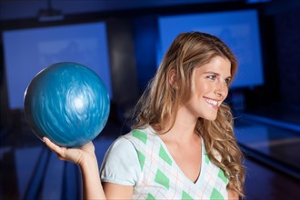 Young smiling woman holding bowling ball. Photo : db2stock