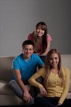 Portrait of teenage boy (16-17) and girl (16-17) with young friend. Photo : Rob Lewine