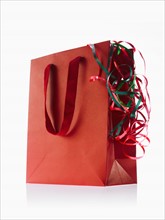 Studio shot of red gift bag with ribbons. Photo: David Arky
