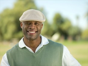 Smiling man on golf course. Photo : db2stock