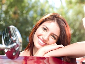 Smiling young woman in convertible car. Photo : db2stock