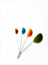 Studio shot of multicolored measuring spoons. Photo: David Arky