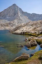 USA, California, Sequoia National Park, Five Lakes trail, Hiker sitting at edge of lake. Photo :