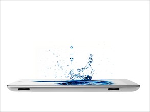 Studio shot of water splashing on digital tablet. Photo : David Arky