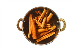 Studio shot of Cinnamon Sticks in pan on white background. Photo: David Arky