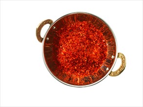 Studio shot of Red Chili Flakes in pan on white background. Photo : David Arky