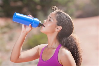 Woman drinking water after jogging. Photo: db2stock