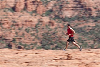 USA, Arizona, Sedona, Young man running in desert. Photo: db2stock