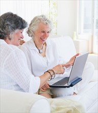 Two senior women with laptop. Photo : Daniel Grill