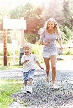 Mother and son (2-3) running on footpath. Photo: Take A Pix Media