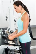 Woman in gym lifting weights.