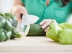 Close up of woman's hand cutting cucumber. Photo : Jamie Grill