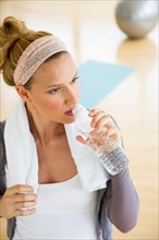 Woman in gym drinking water.