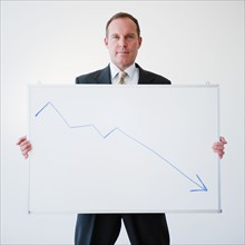 Businessman holding chart. Photo: Jamie Grill