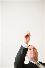 Businessman pointing with pen. Photo: Jamie Grill