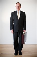 Portrait of businessman with briefcase. Photo: Jamie Grill