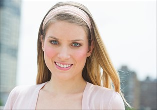 Portrait of young woman smiling outdoors.