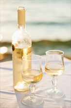 Greece, Cyclades Islands, Mykonos, Wine on table by sea.