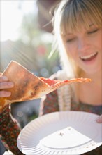USA, Brooklyn, Williamsburg, Woman eating pizza. Photo: Jamie Grill